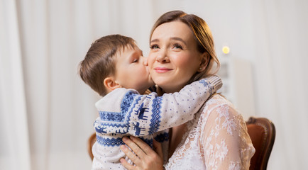 family, expressions and love concept - happy little son kissing his mother