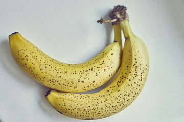 A bunch of two yellow bananas in brown specks