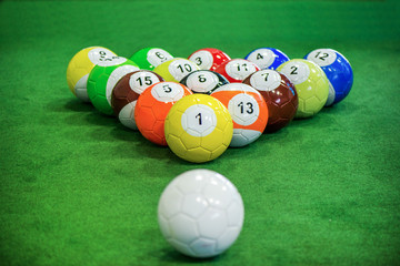 Wall Mural - Shot of foot pool balls standing on green table. Foot Pool is the hybrid combination of pool and soccer. Big billiard balls. 