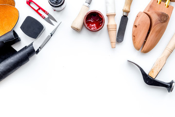 Wall Mural - Clobber tools. Hummer, awl, knife, sciccors, wooden shoe, paint and leather. White background top view space for text