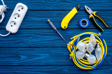 Wall Mural - Electrical repair. Bulbs, socket outlet, cabel, screwdriver, pilers on blue wooden background top view copy space