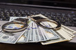 © yaroslav1986 - Handcuffs with money on the laptop keyboard. Top view