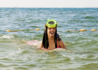 portrait of the happy children with swimming mask on head playing onthe sea beach.