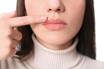 Sticker - Young woman pointing on lips against white background, closeup