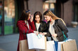 © Vadym - Young girls look into paper bag near shopping mall