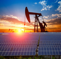 clean power energy concept,oil pump with solar panels and the sunset