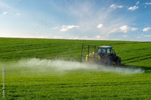 Fotografía Farmer spraying green wheat field