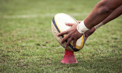 rugby player preparing to kick the oval ball during game