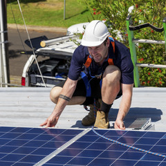 Wall Mural - Solar panel technician with drill installing solar panels