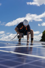 Solar panel technician with drill installing solar panels