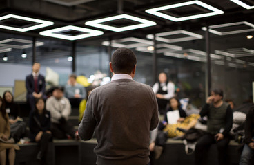 Fototapete - A Man is Speaking to an Audience in Modern Room