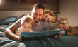 © JenkoAtaman - evening family reading. father reads children . book before going to bed .