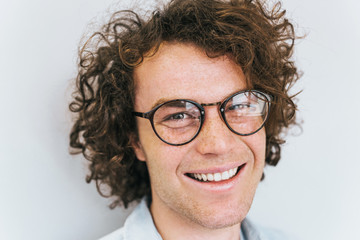 Poster - Closeup cropped portrait of handsome freckled positive male with healthy toothy smile, posing for advertisement, isolated on white wall with copy space for your information or content. People race