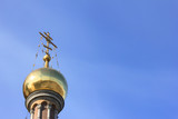 Fototapeta Londyn -  Golden Dome with Cross at Church.  Christian Orthodox Church Architecture Element Isolated on Empty Blue Sky Background. Religious Building Exterior of Old Historic Cathedral with Empty Copy Space.