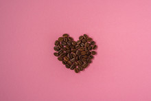 Coffee Beans Shaped Hearts On A Pink Background. Love Coffee Concept