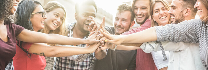 young happy people stacking hands outdoor