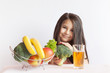 © kaganskaya115 - Happy little girl eating fresh vegetables ,fruits and drinkind fresh juice. A portrait on a white background. Healthy teeth.