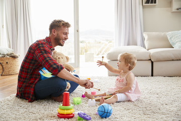 Wall Mural - Father and young daughter playing toy instruments at home