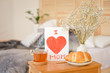 Mother's Morning breakfast on wooden tray near bed with greeting card I love you mom. Mother's Day concept.
