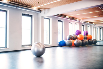 Young woman doing exercise with a fitball in a gym.