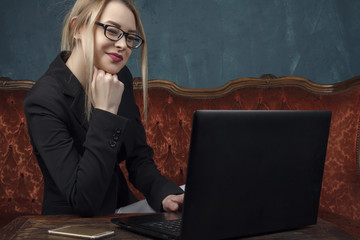 Businesswoman, happy woman in suit smiling using laptop for work in vintage interior