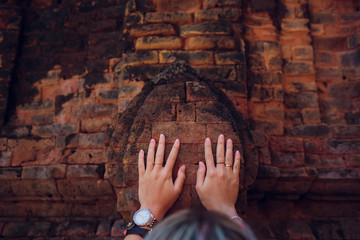 young girl prays against wall temple. concept modern religion