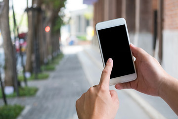 Hands using smartphone on street with empty screen display.