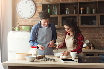 Happy young couple baking in loft kitchen