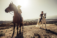 Couple Of Horses And Cowboys Male And Female Ride Free In The Nature At The Mountains In Tenerife. Lifestyle And Alternative Works Or Leisure Activity Concept For Man And Woman