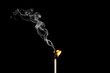© Emilija - Matchstick burning with little flame and smoke on black background