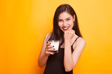 Healthy Asian woman drinking a glass of milk.