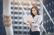 © sunti - Business woman using laptop computer on the BTS station