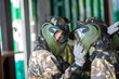 © Natali - Boys dressed in camouflage stand in a row on a paintball base, preparing to start a game
