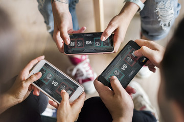 group of diverse friends playing game on mobile phone