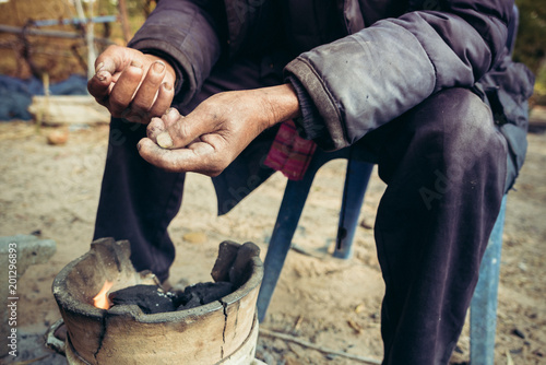 Fotomural portrait old man on rural of Thailand in winter season with the small fireplace