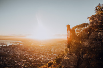 Wall Mural - Young hiker watching sunrise on mountain