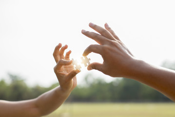 Closeup hands of woman and man connecting jigsaw puzzle