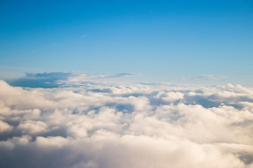 view through plane window, over the clouds after sunrise