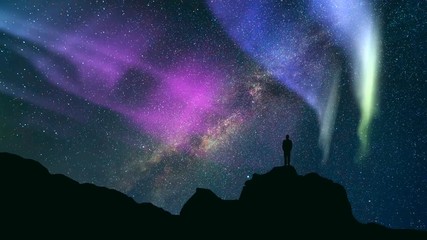 Wall Mural - The man standing on the rock against a northern light. time lapse