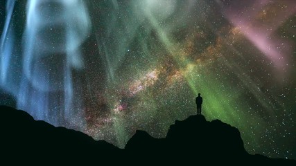 Wall Mural - The man standing on the rock against a starry sky with a northern light