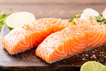 Wall Mural - Fresh raw salmon fillet with aromatic herbs, spices on old wooden background.