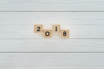 top view of wooden blocks arranged in 2018 on white wooden tabletop