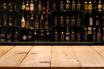 Empty wooden bar counter with defocused background and bottles of restaurant, bar or cafeteria background /for your product display