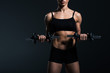 © LIGHTFIELD STUDIOS - cropped view of female bodybuilder working out with dumbbells, isolated on grey