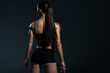 © LIGHTFIELD STUDIOS - rear view of female bodybuilder posing in black sportswear,  isolated on grey