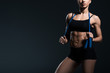 © LIGHTFIELD STUDIOS - partial view of muscular sportswoman with jump rope for cardio training, isolated on grey