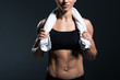 © LIGHTFIELD STUDIOS - cropped view of muscular sportswoman with towel after training, isolated on grey
