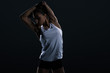 © LIGHTFIELD STUDIOS - beautiful young female bodybuilder stretching, isolated on black
