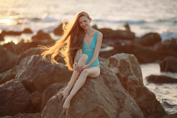 Wall Mural - sensual woman with slim body sitting on rock in water