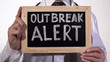 Outbreak alert text written on blackboard in doctor hands, epidemic warning